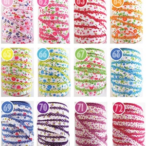 May include: Twelve spools of white ribbon with a floral print and a lace trim. The ribbon is in various colours, including pink, red, orange, yellow, green, blue, purple, and white.