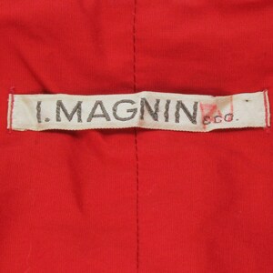 May include: A white label with the text "I. MAGNIN & CO." in black lettering.