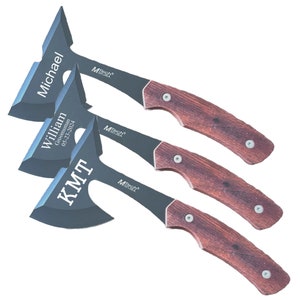 May include: Three personalized black and silver hatchets with brown wooden handles. The hatchets are engraved with the names "Michael", "William Groomman 05-23-2024", and "KMT".