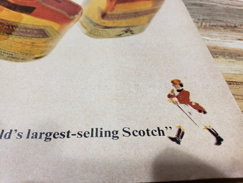 May include: A vintage advertisement for a brand of Scotch whisky. The ad features a man in a red jacket and white pants walking with a walking stick. The text on the ad reads "World's largest-selling Scotch".