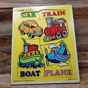 May include: A vintage Playskool wooden puzzle featuring four colorful vehicles: a yellow car, a red train, a green boat, and a blue airplane. The puzzle pieces are shaped like the vehicles and fit into a yellow background with the words "CAR", "TRAIN", "BOAT", and "PLANE" printed below each vehicle.