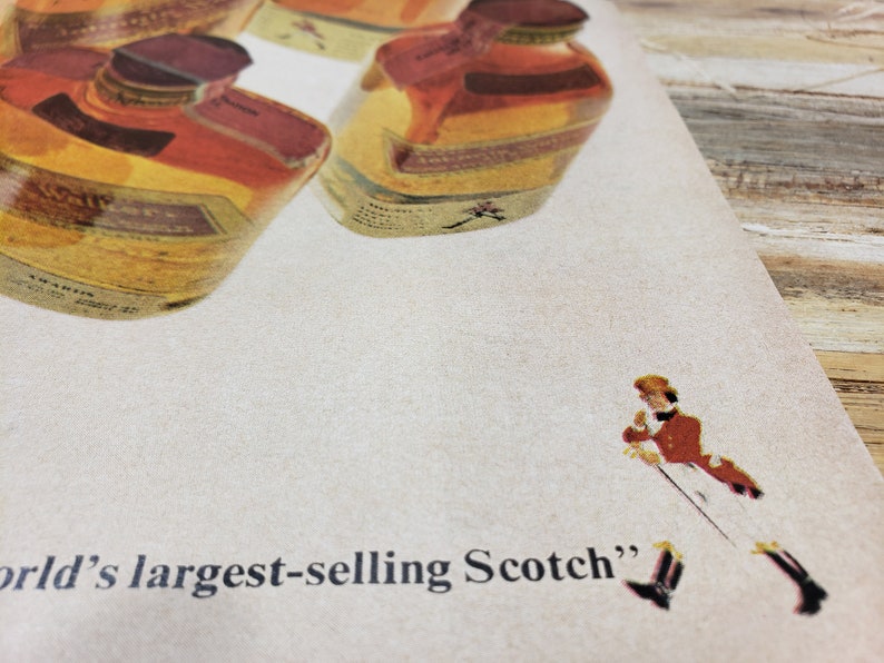 May include: A vintage advertisement for a brand of Scotch whisky. The ad features a close-up of several bottles of Scotch whisky and the text "world's largest-selling Scotch".