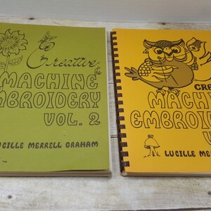 May include: Two green and yellow spiral bound books with illustrations of a sunflower and an owl. The books are titled "Creative Machine Embroidery Vol. 2" and "Creative Machine Embroidery Vol. 3" by Lucille Merrell Graham.