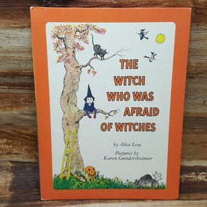 May include: A book cover with an orange background and a picture of a witch sitting on a tree branch. The title of the book is "The Witch Who Was Afraid of Witches" by Alice Low. Pictures by Karen Gundsheimer.