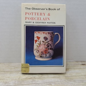 May include: A book titled "The Observer's Book of Pottery & Porcelain" by Mary & Geoffrey Payton. The cover features a white porcelain mug with a floral design in shades of red, pink, and green against a blue background.