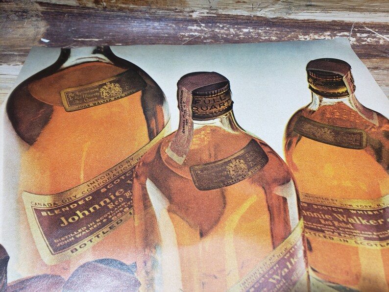 May include: Three glass bottles of blended Scotch whisky. The bottles are labeled "Johnnie Walker Red Label" and "Johnnie Walker Black Label". The bottles are on a light blue background.