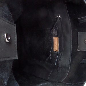 May include: Black leather tote bag with a zippered pocket and a small leather tag that says "MALAGA".