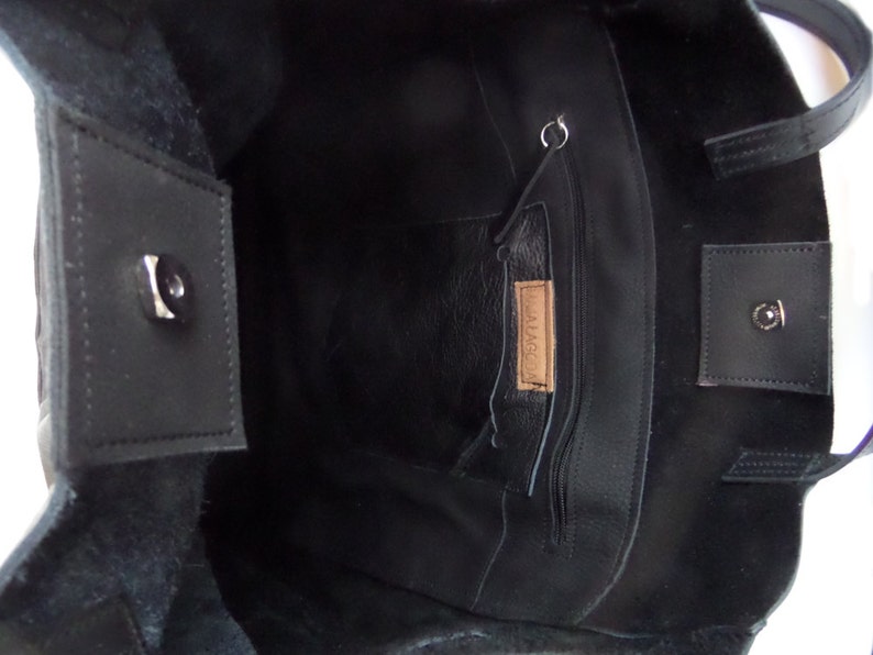 May include: Black leather tote bag with a zippered pocket and a small leather tag that says "MALAGA".