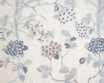 Puede incluir: Una tela blanca con un patrón floral. Las flores son azules, marrones y blancas. La tela tiene una textura sutil.