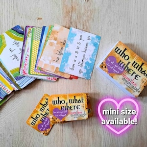 May include: A set of colorful oracle cards with the text "who what where future love oracle cards by Lauren Rose Dulay" on the front. The cards are stacked on a wooden surface. A pink heart with the text "mini size available!" is in the lower right corner of the image.