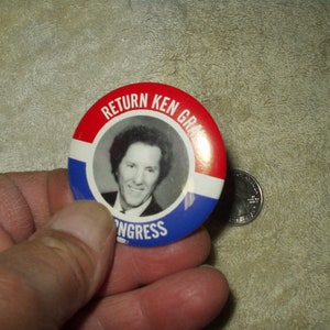 May include: A red, white, and blue button with a photo of a man with curly hair. The button says "Return Ken Gra- ngress".