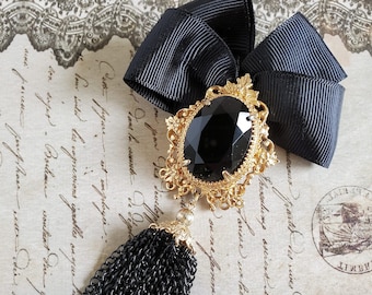 Black Crystal Statement Bow Brooch, Ornate Gold-Tone Setting with Long Tassel
