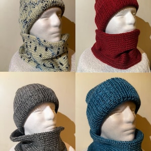 May include: Four knitted hat and neck warmer sets in various colors. The sets include a light beige hat and neck warmer with blue accents, a red set, a gray set, and a teal set. The hats and neck warmers are displayed on mannequin heads.