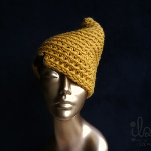 May include: A yellow knitted beanie with a unique pointed shape. The beanie is made with a textured stitch and has a small black detail on the side.