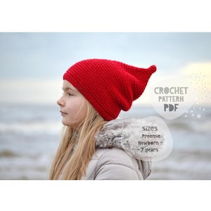 May include: A bright red crochet beanie with a pointed top. The text on the image reads: CROCHET PATTERN PDF, sizes Preemie Newborn - 7 years. The beanie features a textured knit stitch pattern and a slouchy fit, designed for various ages.
