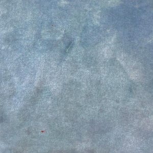 May include: A piece of fabric featuring a mottled, cloud-like pattern in shades of dusty blue, slate gray, and soft white. The textile has a subtle, velvety texture with a consistent, non-directional appearance across the entire surface.