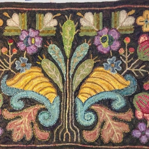 May include: A hand-hooked rug with a dark background and a central floral design. The design features yellow, blue, purple, and red flowers, along with green leaves and stems. The rug's border is a dark brown.
