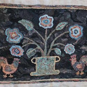 May include: Hand-hooked rug with a dark background, featuring a floral arrangement in a vase and two roosters. The flowers are blue and orange, the vase is green, and the roosters are brown and orange. The rug has a rectangular shape.