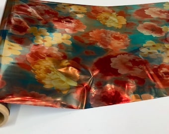 May include: A roll of metallic wrapping paper with a floral pattern in shades of red, orange, yellow, and teal.