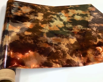May include: A roll of iridescent copper-colored vinyl with a tie-dye pattern. The vinyl has a glossy finish and is perfect for crafting projects.