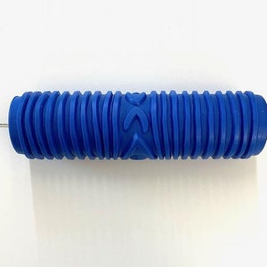 May include: Blue textured paint roller with a repeating pattern of arrows and waves. The roller is approximately 10 inches long.