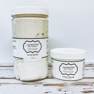 May include: Two white jars of ArtsyVille Embellishments Texture Medium. The larger jar is 32 oz and the smaller jar is 8 oz / 235 ml.