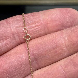 May include: A close-up of a gold chain necklace with a lobster clasp.