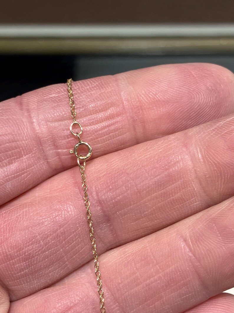 May include: A close-up of a gold chain necklace with a lobster clasp.