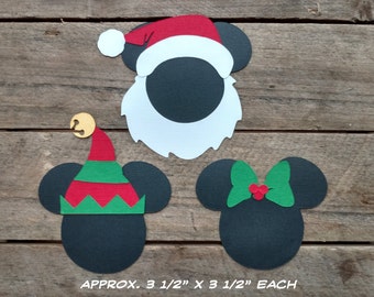 Puede incluir: Tres recortes de papel de personajes de Mickey Mouse vestidos con trajes de Navidad. Los personajes son Santa Claus, un elfo y una Minnie Mouse con un lazo verde. Los recortes miden aproximadamente 3 1/2 pulgadas por 3 1/2 pulgadas cada uno. APPROX. 3 1/2" X 3 1/2" EACH