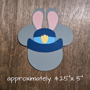 May include: A gray paper cutout of a bunny wearing a blue police hat with a yellow badge. The bunny has pink inner ears. The text "approximately 4.25" x 5"" is at the bottom.