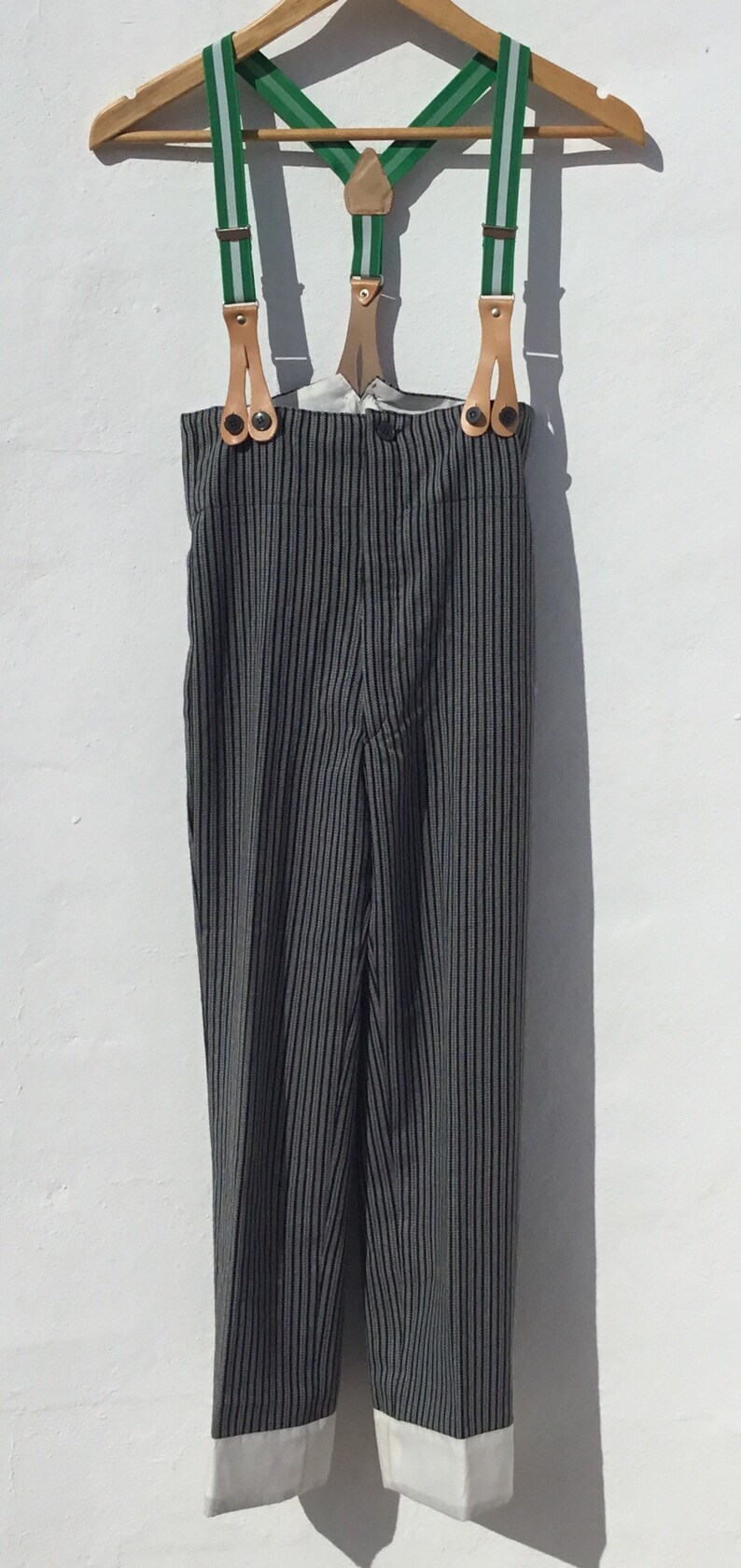 May include: Black and white striped pants with white cuffs and green suspenders with brown leather accents.