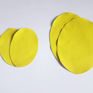 May include: Two sets of yellow felt circles, one set with two circles and the other with three circles.