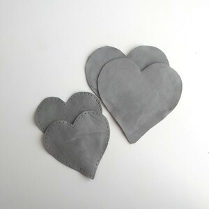 Könnte beinhalten: Drei graue Filzherzen, zwei kleinere Herzen sind in einem größeren Herzen verschachtelt.