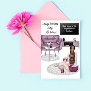 May include: A birthday card featuring a purple sofa, a woman relaxing on a fluffy rug, and a TV screen. The card reads "Happy Birthday Ruby. 16 Today!" and has a space to add a favourite TV programme or film.