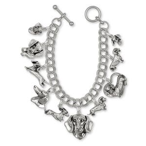 May include: A silver charm bracelet with multiple dachshund dog charms. The bracelet has a lobster clasp and a toggle clasp.