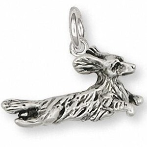 May include: Sterling silver charm of a dachshund dog running. The charm is detailed and realistic, with a textured finish.