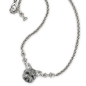 May include: A silver necklace with a Yorkshire Terrier charm and bone accents. The chain is a delicate, twisted design.