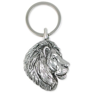 May include: Silver-toned lion head keychain. The lion's head is facing to the right and has a detailed mane.