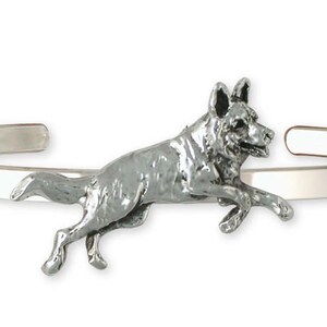 May include: A silver bracelet with a German Shepherd dog charm. The dog is depicted in a running pose.