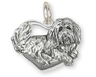 Puede incluir: Encanto de plata de ley de un perro Shih Tzu acostado en forma de corazón.