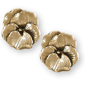 May include: Two gold-colored, pansy-shaped decorative objects. Each pansy has multiple textured petals and a detailed center. The objects are likely made of metal and are displayed against a white background.