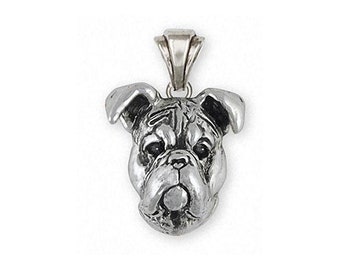 Puede incluir: Pendiente de plata con la cabeza de un bulldog detallada. El pendiente es una representación realista de la cara de un bulldog, con la frente arrugada, el hocico corto y el labio inferior caído.
