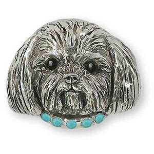 May include: A silver charm of a Shih Tzu dog with a turquoise stone collar.