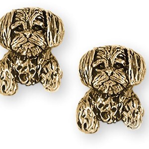 May include: A pair of gold-tone earrings featuring a detailed, three-dimensional design of a Shih Tzu dog.
