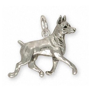 May include: Sterling silver charm of a Rat Terrier dog running. The charm is detailed and realistic, capturing the breed's distinctive features.