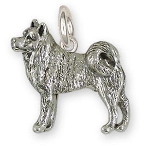 May include: A silver-colored charm in the shape of a dog, likely an Akita, with detailed fur texture. The charm is in a standing pose, with a loop at the top for attachment to a necklace or bracelet. The dog charm is a jewelry item.