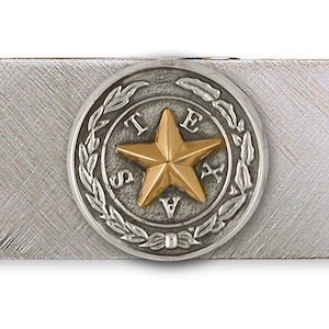May include: Silver money clip with a gold-colored five-pointed star in a circle with the word "TEXAS" around it.