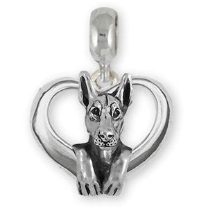 May include: Silver charm in the shape of a heart with a Doberman Pinscher dog inside.
