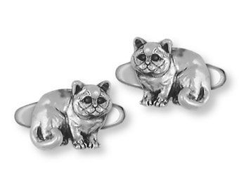 May include: A pair of silver cufflinks featuring a detailed sculpture of a cat sitting with its tail curled around its body.