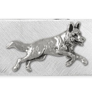 May include: Silver money clip featuring a German Shepherd dog running. The dog is in a silver finish and is set against a brushed silver background.